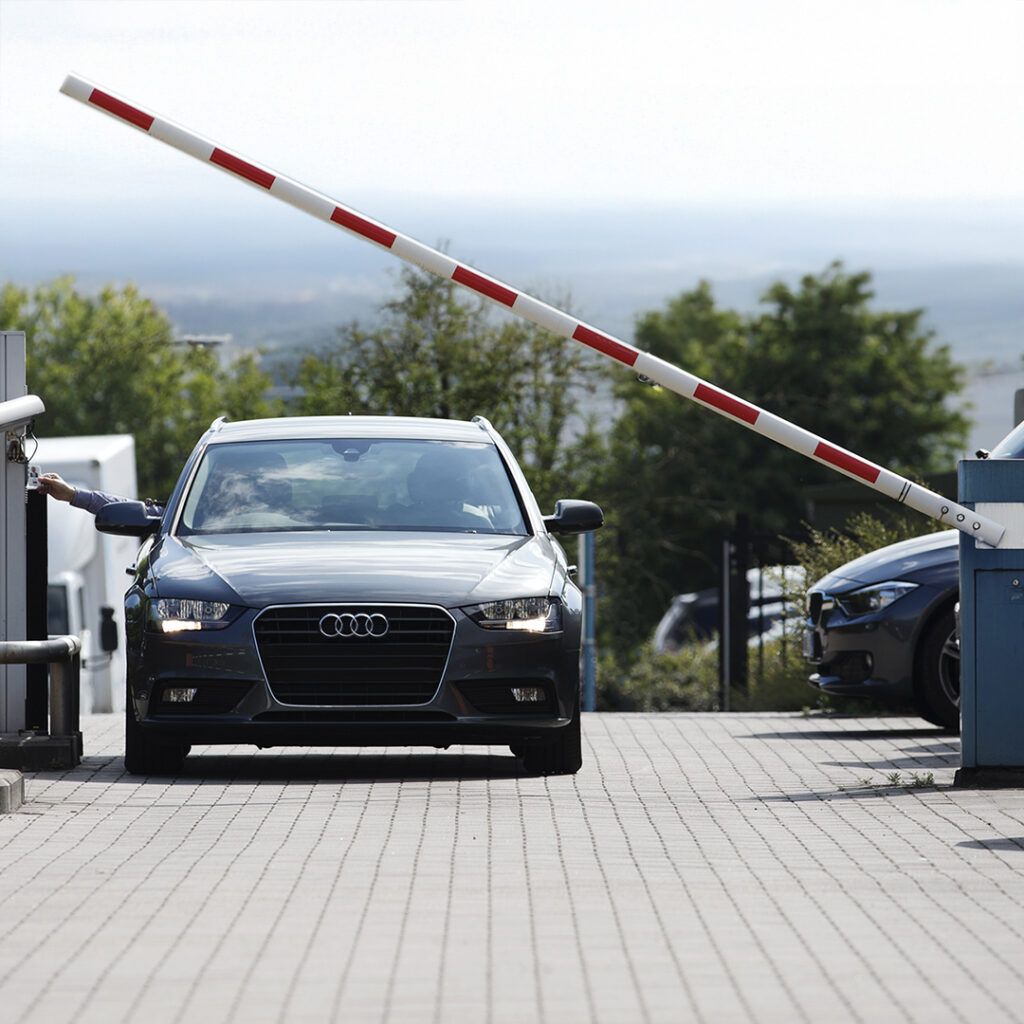 Barrière levante automatique ouverte pour laisser passer un véhicule sur un site sécurisé, contrôle d’accès par badge à l’entrée.