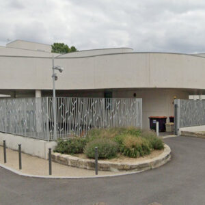 Clôture décorative en acier thermolaqué installée autour d’un bâtiment public moderne.