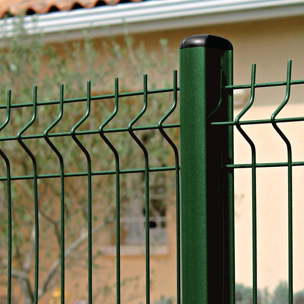 Clôture en treillis soudé vert fixée sur un poteau tubulaire rond, posée devant une maison.
