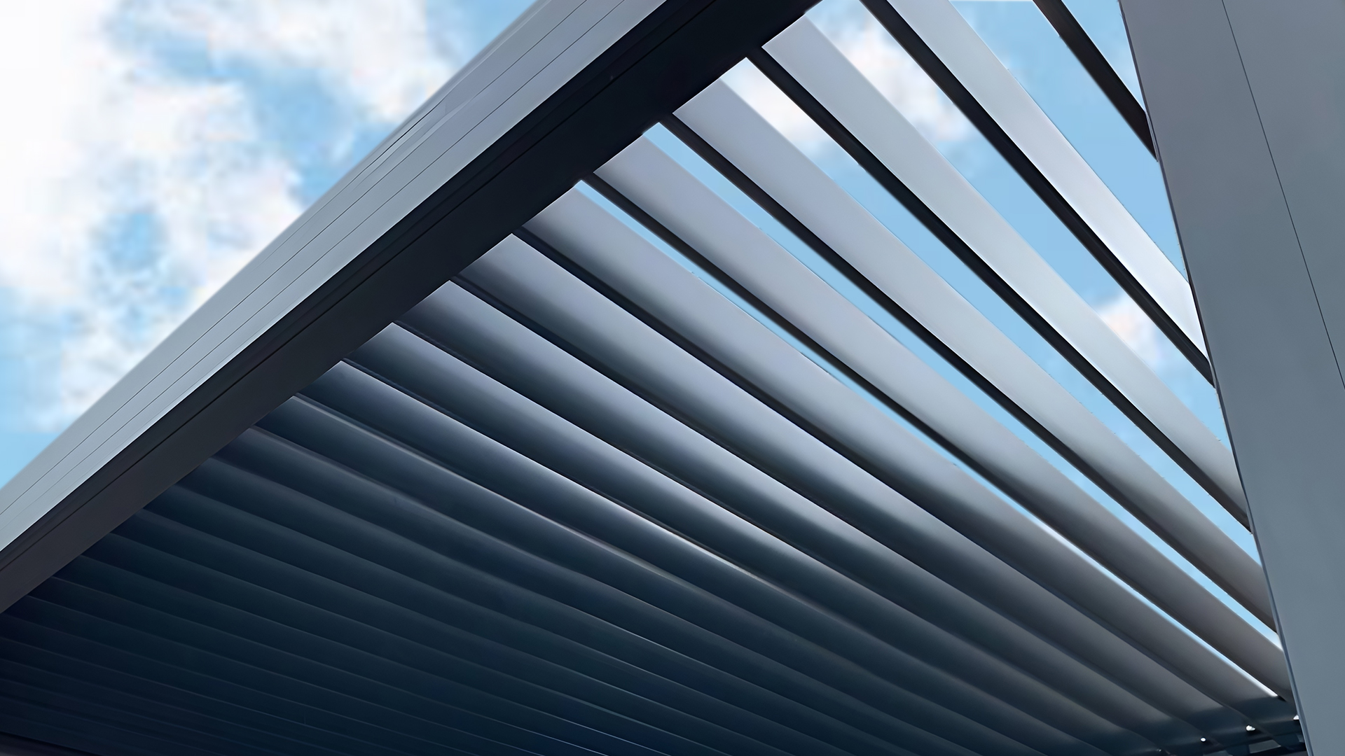 Vue en contre-plongée d’une pergola à lames orientables en aluminium.