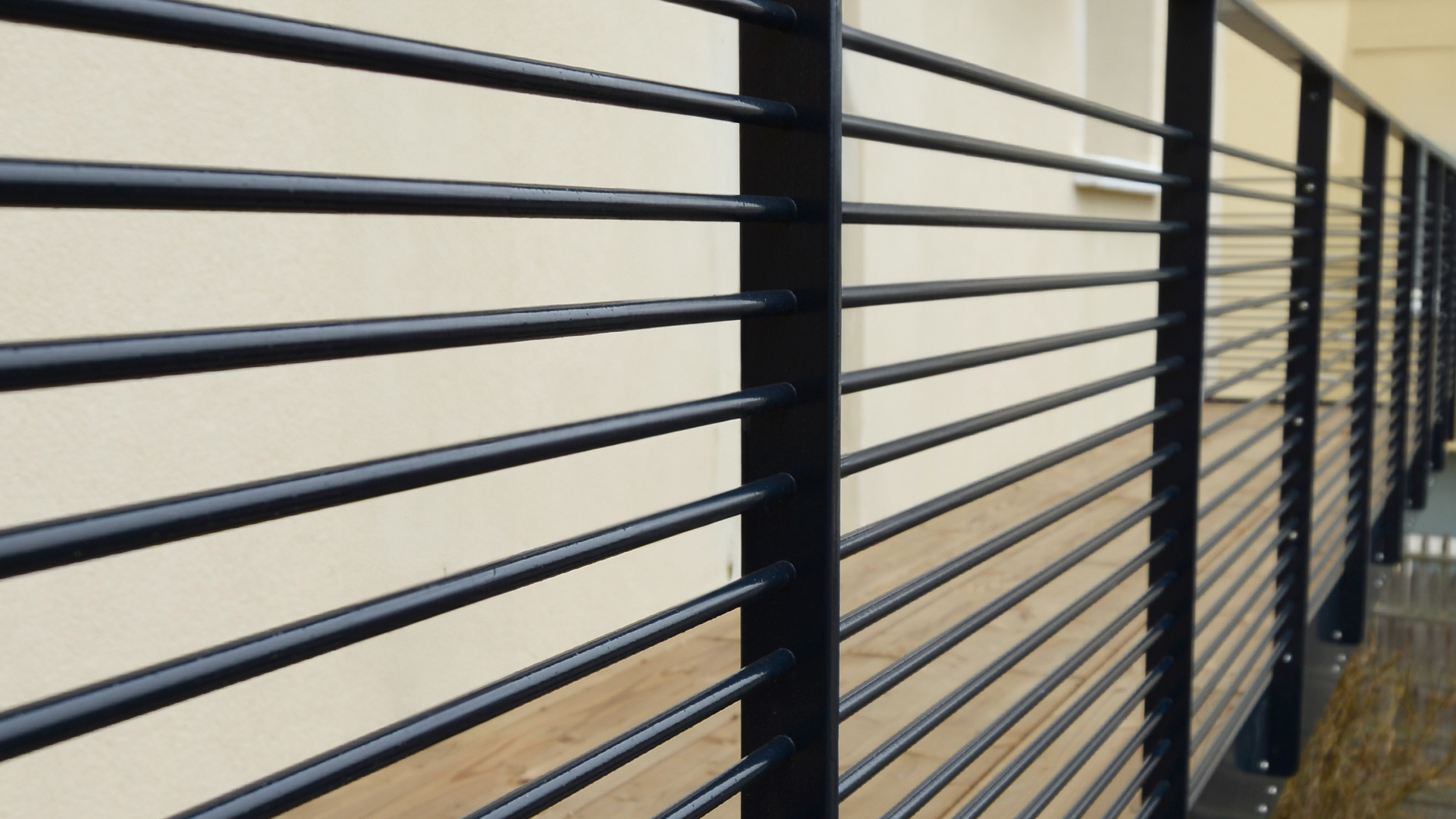 Garde-corps en acier thermolaqué noir à barreaudage horizontal, installé en extérieur le long d’une terrasse surélevée.