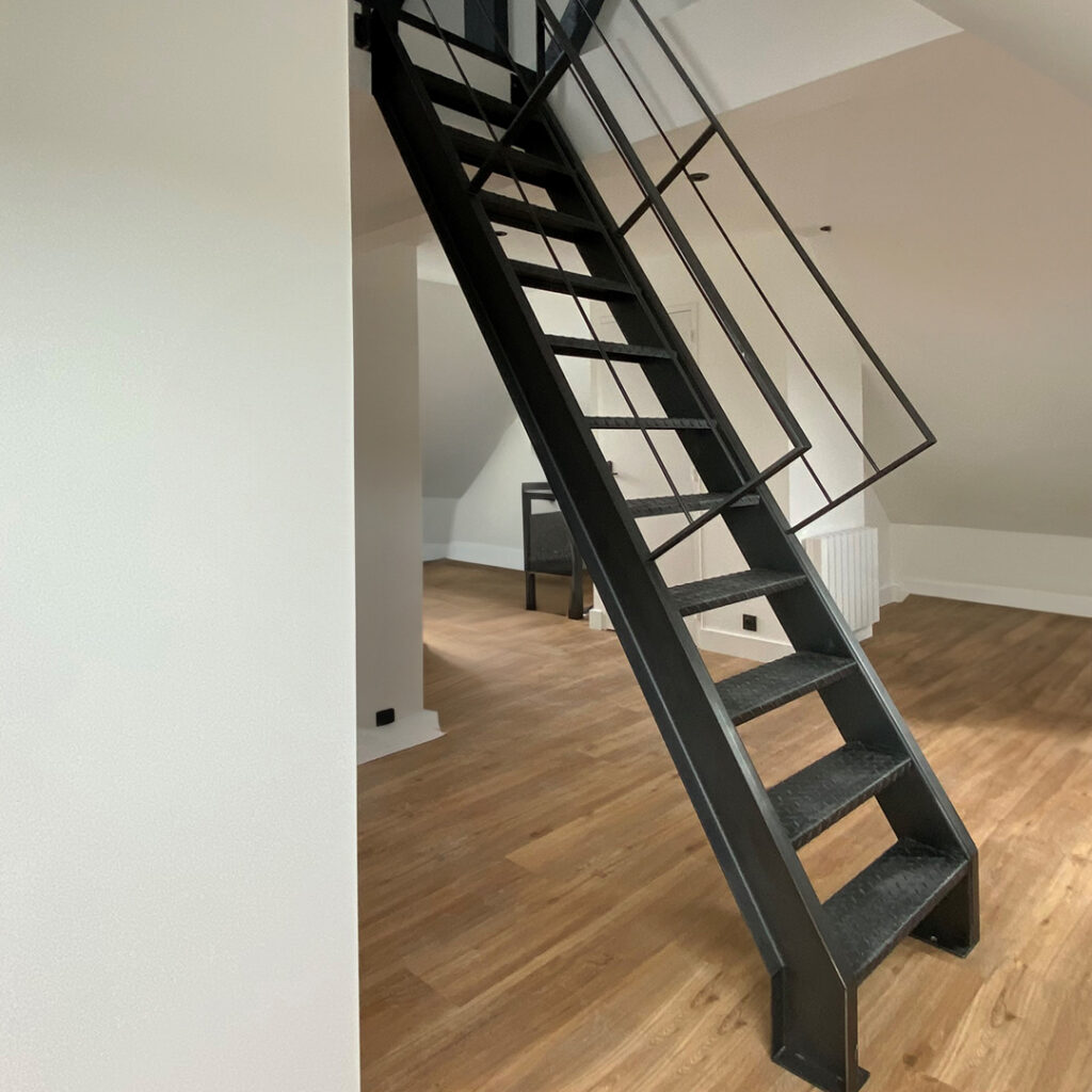 Escalier de meunier en acier noir avec marches antidérapantes, dans un intérieur moderne.