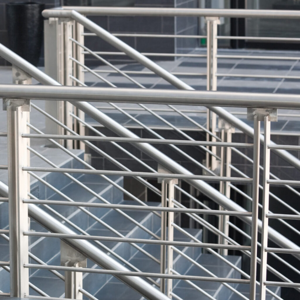 Garde-corps en inox à lisses horizontales, installé sur passerelles et escaliers dans un bâtiment contemporain à revêtement carrelé.