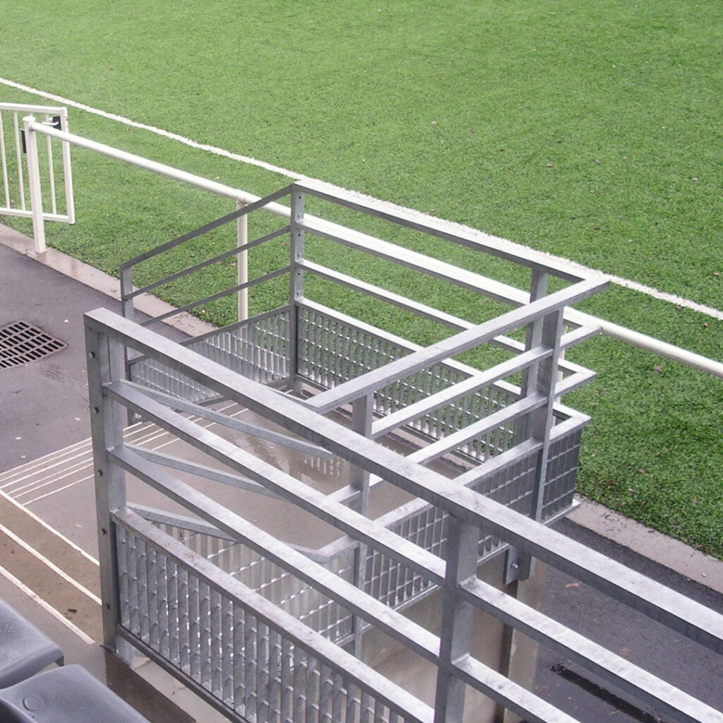 Garde-corps en acier galvanisé, installé en tribune de stade pour sécuriser l’accès et les circulations des spectateurs.