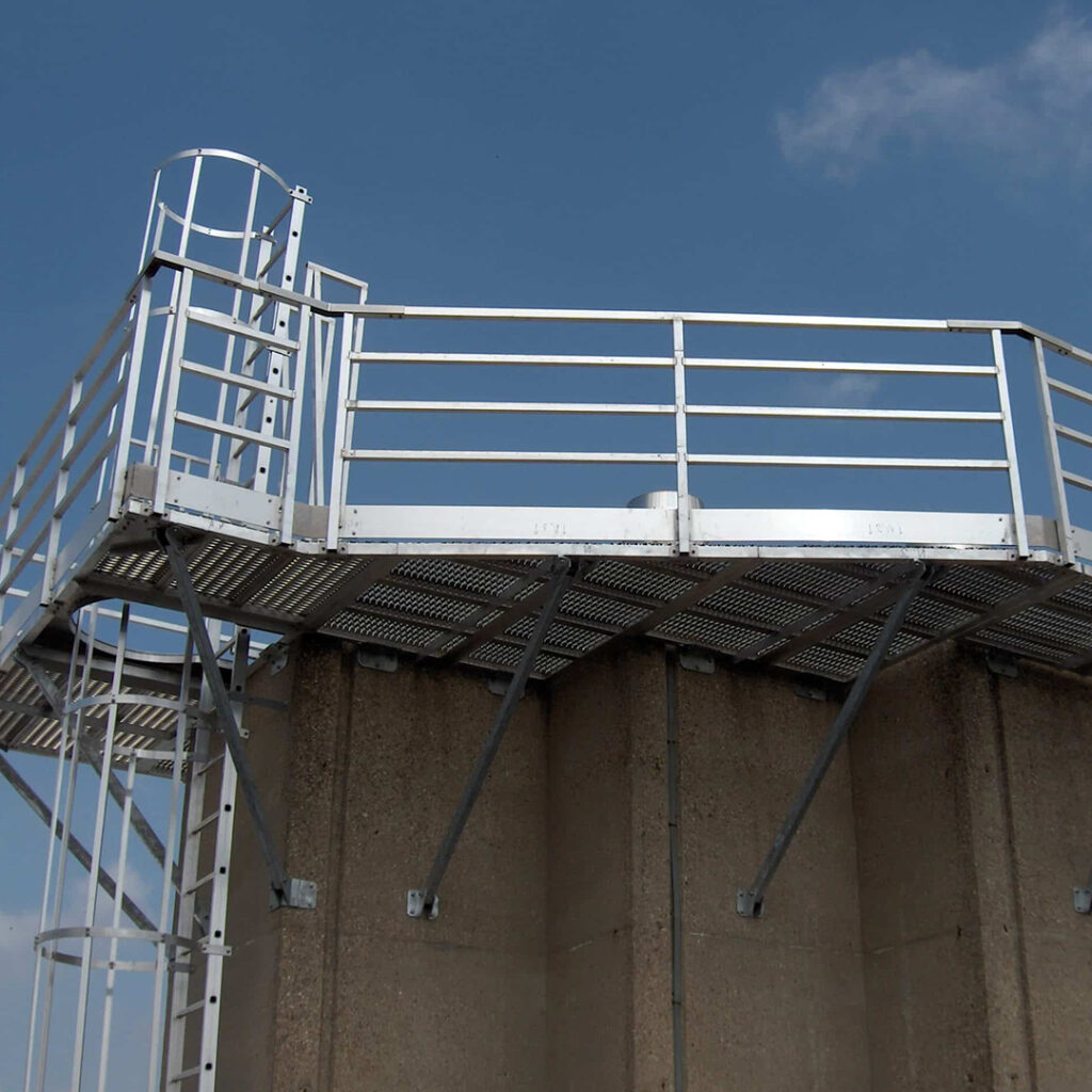 Passerelle industrielle en aluminium fixée en hauteur avec garde-corps et échelle à crinoline.