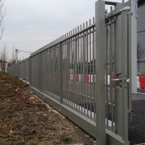 Portail autoportant métallique gris installé sur un site industriel.