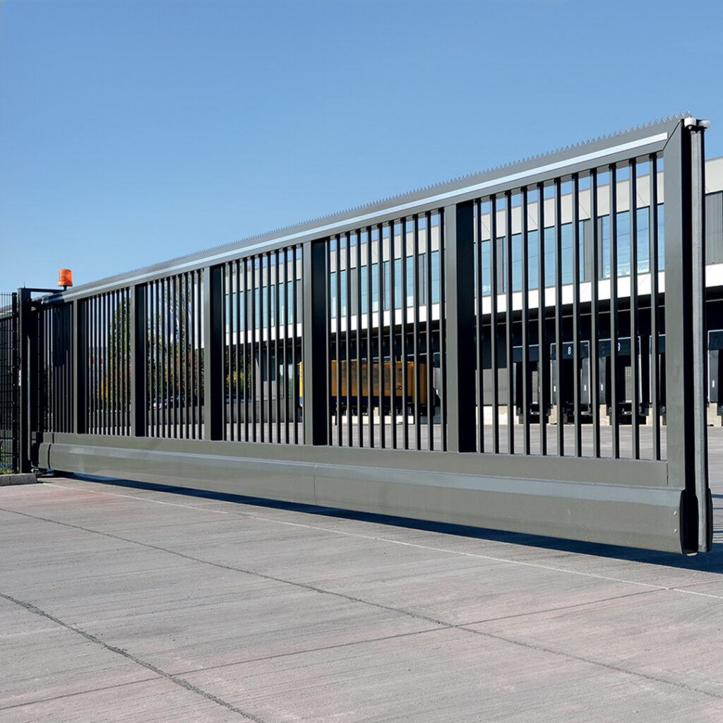 Portail autoportant industriel à barreaudage vertical avec motorisation intégrée.